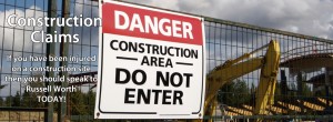 An image of a sign on a herris fence in front of a buiding yard saying Danger, construction area, DO NOT ENTER