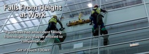 An image of two workers working to replace a window pane at height via harnesses and pullys